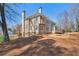 Rear exterior view with multi-story windows, outdoor patio, and landscaped yard for entertaining at 7270 Sheffield Pl, Cumming, GA 30040