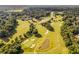 Scenic aerial of the golf course with tree-lined fairways, sand traps and a tranquil pond at 7270 Sheffield Pl, Cumming, GA 30040