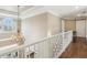 Bright hallway with hardwood floors, chandelier, and natural light from large window at 7270 Sheffield Pl, Cumming, GA 30040