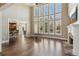 Bright living room features hardwood floors, tall windows, and a stone fireplace at 7270 Sheffield Pl, Cumming, GA 30040