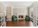 Cozy living room with hardwood floors, fireplace, and green armchairs at 7270 Sheffield Pl, Cumming, GA 30040