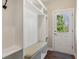 Mudroom featuring built-in shelving, a bench, and an exterior door at 7270 Sheffield Pl, Cumming, GA 30040