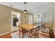 Dining room with wood table, chairs, mirrored wall, modern light fixture, and view to modern kitchen at 101 Natchez Trce, Atlanta, GA 30350