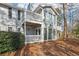 Rear exterior view features two stories, a patio, treelined yard, and windows that create an abundance of natural light at 101 Natchez Trce, Atlanta, GA 30350