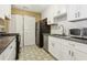 Bright kitchen featuring white cabinets, stainless steel appliances, and decorative flooring at 101 Natchez Trce, Atlanta, GA 30350