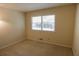 A simple carpeted bedroom featuring natural light from a window with blinds at 4042 Shady Nw Cir, Lilburn, GA 30047