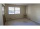 A simple bedroom with a window providing natural light to the carpeted floor and neutral walls at 4042 Shady Nw Cir, Lilburn, GA 30047