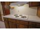 Kitchen cooktop with a white countertop and wood cabinets at 4042 Shady Nw Cir, Lilburn, GA 30047