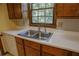 Well-lit kitchen sink with stainless steel fixtures and wooded outdoor view at 4042 Shady Nw Cir, Lilburn, GA 30047