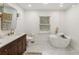 Bright bathroom with a freestanding tub, modern fixtures, and a wooden vanity at 410 Wilkinson Se Dr, Atlanta, GA 30317