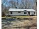 Single-story home with white siding and metal roof, complemented by a spacious yard at 7301 Staton Pl, Acworth, GA 30102