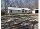 View of the side and front of single-story home with storage shed and gravel drive at 7301 Staton Pl, Acworth, GA 30102