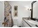 Bright bathroom features a colorful shower curtain, granite countertops, and decorative vintage-inspired artwork at 1421 Peachtree Ne St # 415, Atlanta, GA 30309