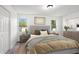A bright bedroom featuring a gray upholstered bed, two windows and matching nightstands and dressers at 2113 Pine Tree Trl, Atlanta, GA 30349