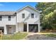 Two-story townhouse showcasing a white exterior, black garage door, and well-maintained driveway at 2113 Pine Tree Trl, Atlanta, GA 30349
