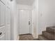 Entry hallway with carpeted stairs and access to a room with tiled flooring at 2113 Pine Tree Trl, Atlanta, GA 30349