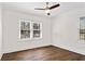 Bright bedroom featuring dark wood floors, a ceiling fan, and a window with natural light at 4178 Castle Pines Ct, Tucker, GA 30084
