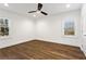 Serene bedroom with hardwood floors, a ceiling fan, and natural light from two windows at 4178 Castle Pines Ct, Tucker, GA 30084