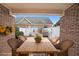 Covered patio with brick columns, wood table, wicker chairs, and views of the fenced yard at 970 Prance Dr, Kennesaw, GA 30144
