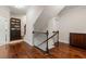 View of the wooden staircase landing featuring hardwood floors, iron railing, and custom dark wood built-in bookcase at 1818 Cromwell Walk, Dunwoody, GA 30338