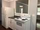 Compact kitchen with white appliances, granite countertops, and ample cabinet space at 23 Holub Path, Dallas, GA 30157