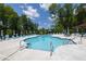 Sparkling community pool surrounded by lounge chairs, umbrellas, and lush greenery at 2400 Edgar Park Pl # 103, Duluth, GA 30096