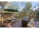 Outdoor dining area with a table, chairs, umbrella, and grill set on a wooden deck surrounded by trees at 313 5Th Ne St, Atlanta, GA 30308