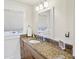 Bright bathroom featuring a granite countertop, window with blinds, and a well-lit vanity mirror at 313 5Th Ne St, Atlanta, GA 30308