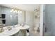 Elegant bathroom featuring double sinks, a glass shower, and tasteful decor, illuminated by modern lighting at 313 5Th Ne St, Atlanta, GA 30308