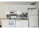 Functional kitchen with white appliances, cabinets, and grey backsplash, offering a clean and efficient space at 313 5Th Ne St, Atlanta, GA 30308