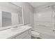 Bright bathroom featuring a shower-tub combo, toilet, and vanity with sleek white countertops and a large mirror at 5940 Hampton Ct, Atlanta, GA 30349