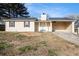 Charming single-story home with light yellow siding, a well-manicured lawn, and an attached carport at 9515 Deerfield Ln, Jonesboro, GA 30238
