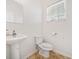 Simple bathroom with a pedestal sink, toilet, and window at 1000 Beckwith Sw St, Atlanta, GA 30314