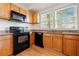 Kitchen with wooden cabinets, granite countertops, and black appliances at 1000 Beckwith Sw St, Atlanta, GA 30314