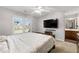 Bright bedroom featuring a large window, TV, ceiling fan, and a view of the bathroom at 4005 Princeton Trce, Cumming, GA 30041