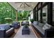 Inviting back porch with modern seating, stylish rug, and a serene view of the wooded backyard at 836 Bailey Woods Rd, Dacula, GA 30019