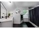 Modern bathroom features a white vanity, a sleek mirror, and elegant black tile flooring at 836 Bailey Woods Rd, Dacula, GA 30019