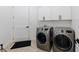 Modern laundry room with front load washer and dryer and white cabinets at 836 Bailey Woods Rd, Dacula, GA 30019