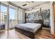 Bright bedroom features wood floors, city skyline mural, and balcony access with city views at 1080 Peachtree Ne St # 1812, Atlanta, GA 30309