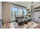 Comfortable living room with cityscape views through large windows, stylish decor and wood floors at 1080 Peachtree Ne St # 1812, Atlanta, GA 30309