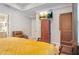 Bedroom with a tray ceiling, an armoire, and a TV with a brown leather couch at 145 Treeside Ter, Fayetteville, GA 30214