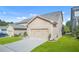 Exterior view of a home showcasing its two-car garage, driveway, and manicured lawn at 145 Treeside Ter, Fayetteville, GA 30214