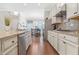Bright eat-in kitchen boasts granite counters, stainless appliances, and hardwood floors at 145 Treeside Ter, Fayetteville, GA 30214