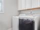 Laundry room with a front load washing machine, dryer, and white cabinets for storage at 145 Treeside Ter, Fayetteville, GA 30214