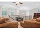 Upstairs living room with brown couches and chairs with a ceiling fan and natural light at 145 Treeside Ter, Fayetteville, GA 30214