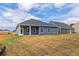 Expansive backyard featuring blue siding, sliding glass doors, and a well-maintained lawn at 246 Orwell Dr, Social Circle, GA 30025