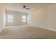 Large bedroom with a ceiling fan and natural light from the windows with blinds and neutral carpet flooring at 246 Orwell Dr, Social Circle, GA 30025