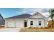 Charming single-story home featuring a two-car garage, brick accents, and a well-maintained front yard at 246 Orwell Dr, Social Circle, GA 30025