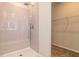 Modern shower with tiled walls and a built-in bench, located next to a walk-in closet area at 246 Orwell Dr, Social Circle, GA 30025