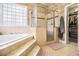 Bright bathroom features tiled steps up to a soaking tub, a glass-enclosed shower, and walk-in closet at 3901 Cherry Ridge Blvd, Decatur, GA 30034